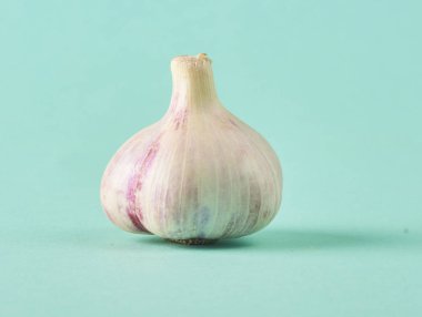 Gıda kavramı. Turkuaz arka plan üzerinde taze Çiğ sarımsak