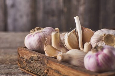 Ahşap kutu taze Çiğ sarımsak ampuller çok yakın çekim görünümünü rustik gri arka plan üzerinde