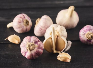 Çiğ spacy sarımsak ampuller ve diş görünümünü yakın çekim siyah ahşap tahta üzerinde