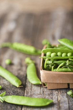 Hearthy taze yeşil bezelye ve bakla ahşap kutusunda yakın çekim görünümünü rustik arka plan üzerinde