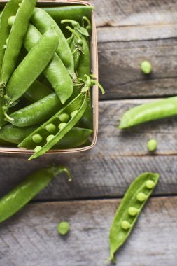 Hearthy taze yeşil bezelye ve bakla ahşap kutusunda yakın çekim görünümünü rustik arka plan üzerinde