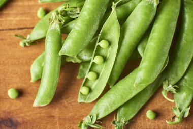 Hearthy taze yeşil bezelye ve bakla yakın çekim görünümünü rustik arka plan üzerinde