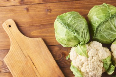 kesme tahtası ve ahşap arka plan üzerinde bıçak ile lahana türleri. Üstten görünüm