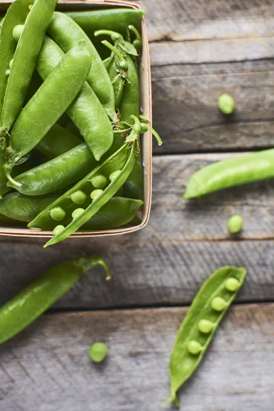 Hearthy taze yeşil bezelye ve bakla ahşap kutusunda yakın çekim görünümünü rustik arka plan üzerinde