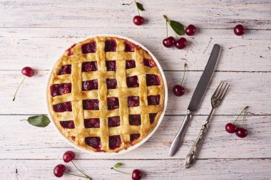 Rustik ahşap beyaz arka plan üzerinde bir lapa lapa kabuk ile lezzetli ev yapımı kiraz turtası. Üstten görünüm