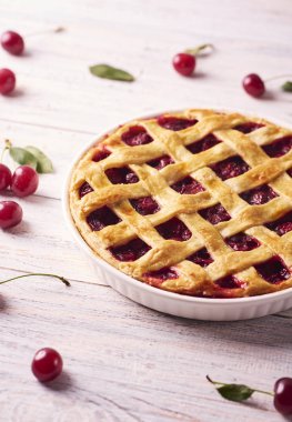 Rustik ahşap beyaz arka plan üzerinde bir lapa lapa kabuk ile lezzetli ev yapımı Cherry Pie