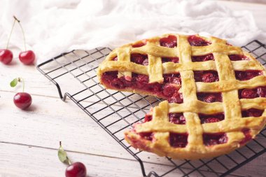 Bir parça lezzetli ev yapımı kiraz kek rustik ahşap beyaz arka plan üzerinde bir lapa lapa kabuk ile