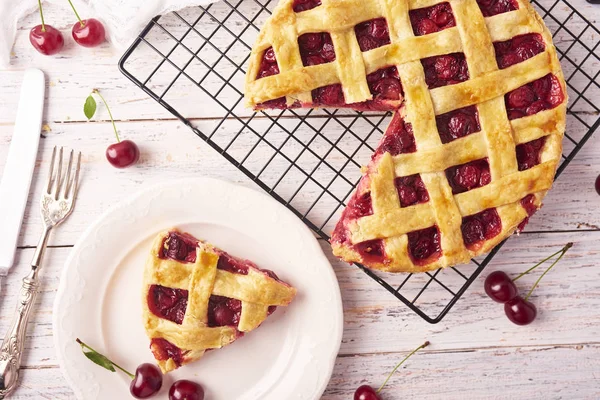 Bir parça lezzetli ev yapımı kiraz kek rustik ahşap beyaz arka plan üzerinde bir lapa lapa kabuk ile