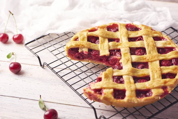 Bir parça lezzetli ev yapımı kiraz kek rustik ahşap beyaz arka plan üzerinde bir lapa lapa kabuk ile