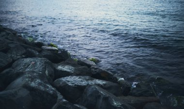 Dalga deniz taş üzerinde günbatımı zamanında sıçramasına. Dramatik görüntü