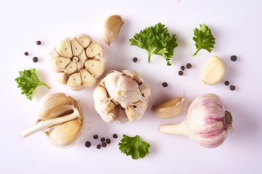 Gıda kavramı. Taze sarımsak, kişniş yaprakları ve beyaz arka plan üzerinde izole biber ile kompozisyon