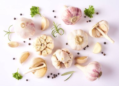 Gıda kavramı. Taze sarımsak, kişniş, fesleğen ve biberiye yaprakları ve beyaz arka plan üzerinde izole biber kompozisyonu