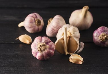 Çiğ spacy sarımsak ampuller ve diş görünümünü yakın çekim siyah ahşap tahta üzerinde