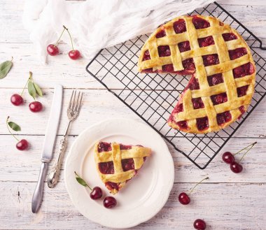 Bir parça lezzetli ev yapımı kiraz kek rustik ahşap beyaz arka plan üzerinde bir lapa lapa kabuk ile