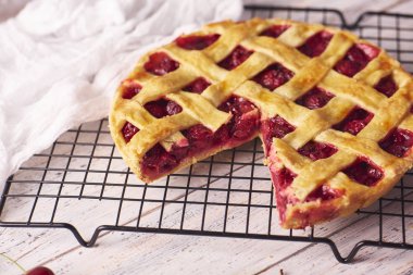 Bir parça lezzetli ev yapımı kiraz kek rustik ahşap beyaz arka plan üzerinde bir lapa lapa kabuk ile