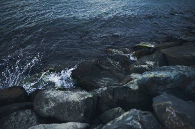 Dalga deniz taş üzerinde günbatımı zamanında sıçramasına. Dramatik görüntü