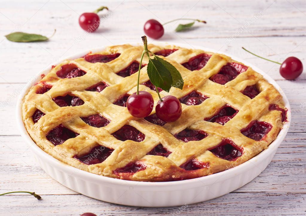 Delicious Homemade Cherry Pie with a Flaky Crust on rustic wooden white background