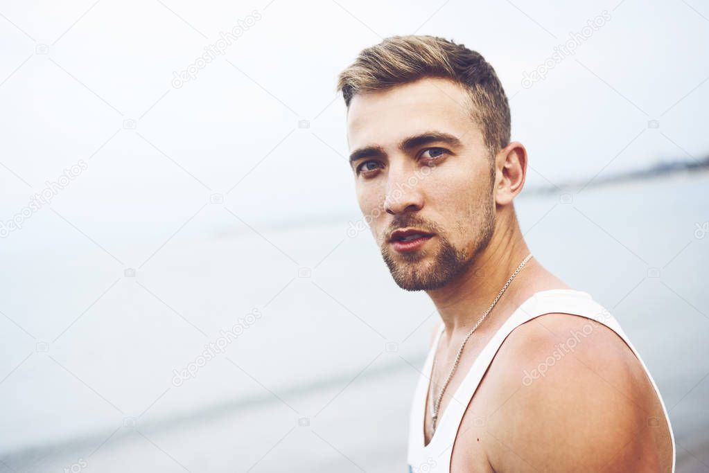 Outdoor lifestyle portrait with young handsome guy on the beach
