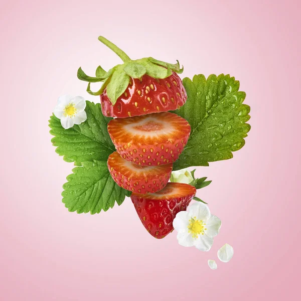 Flying Fresh tasty ripe strawberry with green leaves isolated on pink background.  Food levitation concept. Creative food layout, High resolution image