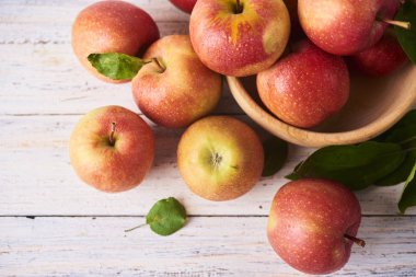 Ahşap kase taze sulu olgun kırmızı elma tablo, yakın çekim beyaz