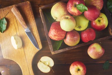 Ahşap kutusunda, taze olgun elma ahşap kahverengi zemin kurulu bıçak ve elma yarısı ile kesme