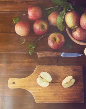 Kase, taze olgun elma ahşap kahverengi zemin kurulu bıçak ve elma yarısı ile kesme