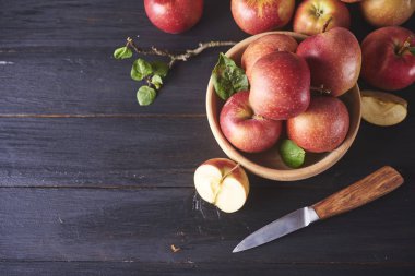 Bıçak ile ahşap masa üzerinde taze sulu olgun kırmızı elma