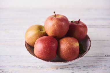 Taze meyve suyu olgun kırmızı elmalar ahşap beyaz masada kasede