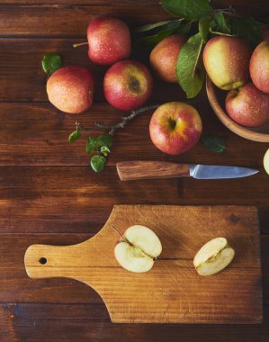 Kase, taze olgun elma ahşap kahverengi zemin kurulu bıçak ve elma yarısı ile kesme