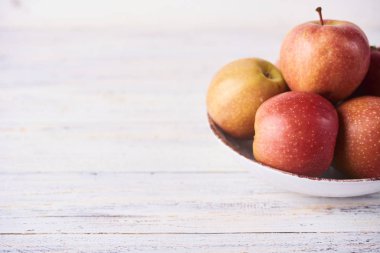 Taze meyve suyu olgun kırmızı elmalar ahşap beyaz masada kasede