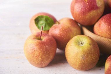 Ahşap kase taze sulu olgun kırmızı elma tablo, yakın çekim beyaz