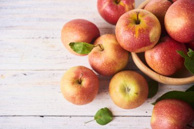 Taze meyve suyu olgun kırmızı elmalar ahşap beyaz masada kasede