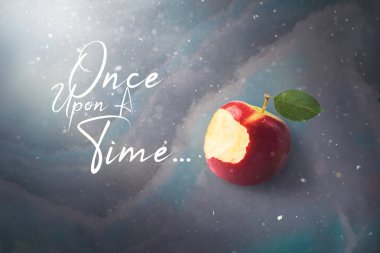 Masal masal kavramı ile mermer, güneş ışığı döşeme ısırıldı kırmızı elma zehirli ve defocused yağan kar, üstten görünüm, yüksek kaliteli görüntü. Bir zamanlar.