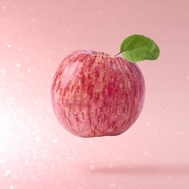 Uçan hava kırmızı pembe bir arka plan, gıda havaya yükselme kavramı, yüksek kaliteli taze elma