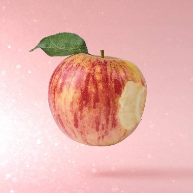 Uçan hava dolu kırmızı taze elma pembe bir arka plan, gıda havaya yükselme kavramı, yüksek kalite