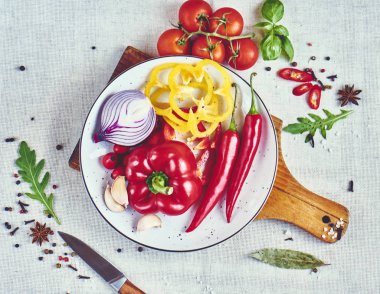 Baharatlar, fesleğen, roka, domates, soğan, bıçak ve kırmızı biber biber, üstten görünüm ile plaka kıyılmış renkli biber