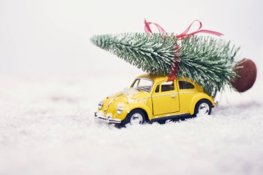 Sarı oyuncak araba kar ile Noel ağacına