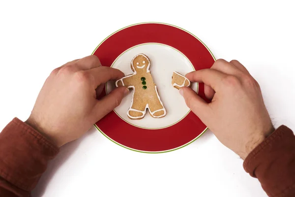 Man\'s hands holding fork and knife with gingerbread man