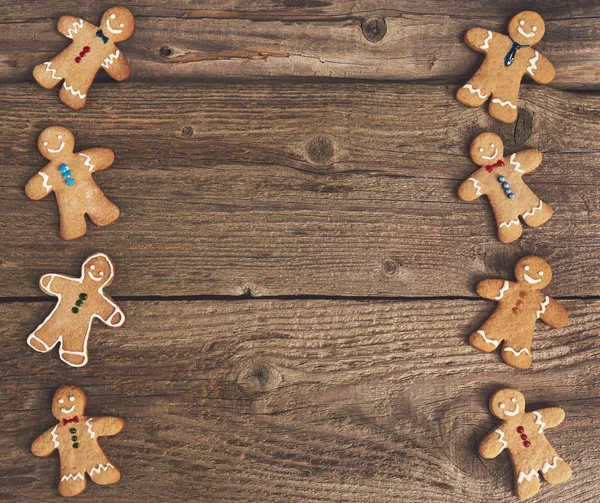 Smiling gingerbread christmas men over wood board