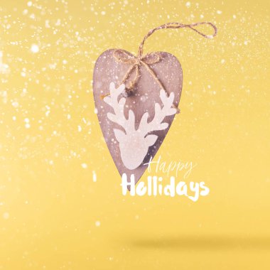 Noel kavramı. Yaratıcı Noel gebe düşen tarafından yapılan Noel ahşap geyik sarı arka plan üzerinde hava. En az kavramı
