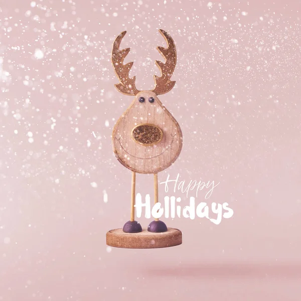 Christmas concept.  Creative Christmas conception made by falling in air christmas wooden deer over pinkbackground. Minimal concept