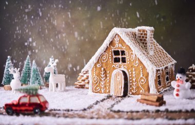 Ev yapımı kurabiye evi. Noel kavramı. Gingerbread house, çerezler, ağaç ile küçük araba oyuncak ve arka plan, Noel ağacı ile geyik