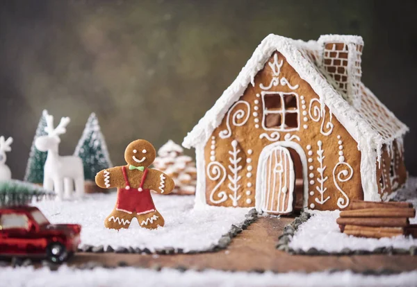 Homemade gingerbread house. Christmas concept. gingerbread house, cookies, tiny car toy with tree and deer with christmas tree at background