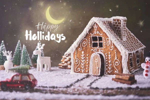 自家製のジンジャーブレッド家 クリスマスのコンセプトです ジンジャーブレッドの家 クッキー 小さな車のおもちゃ木と背景のクリスマス ツリーと鹿 — ストック写真