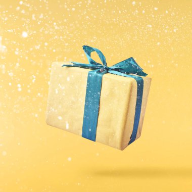 Noel kavramı. Yaratıcı Noel anlayışı sarı arka plan üzerinde hava hediye kutusunda düşerek yaptı. En az kavramı