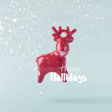 Noel kavramı. Yaratıcı Noel kavramı mavi arka plan üzerinde kırmızı hava Noel geyik oyuncak düşerek yaptı. En az kavramı