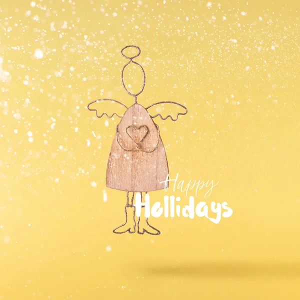 圣诞节的概念 创意圣诞构想通过落在空气中的圣诞木制天使玩具在黄色背景 最小的概念 — 图库照片