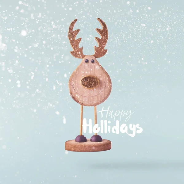 Christmas concept.  Creative Christmas conception made by falling in air christmas wooden deer over blue background. Minimal concept