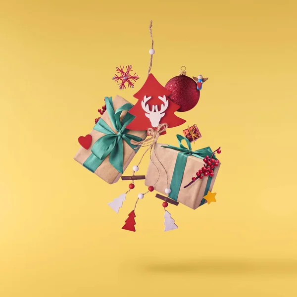 クリスマスのコンセプトです 創造的なクリスマスの概念黄色背景空気ギフト ボックス クリスマスの装飾 玩具転倒によって行われました 最小限のコンセプト — ストック写真