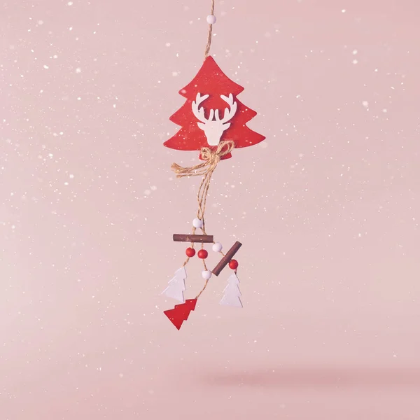 Christmas concept.  Creative Christmas conception made by falling in air christmas decoration with deer and tree over pink background. Minimal concept